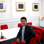 Dr. Lam smiling in a conference room